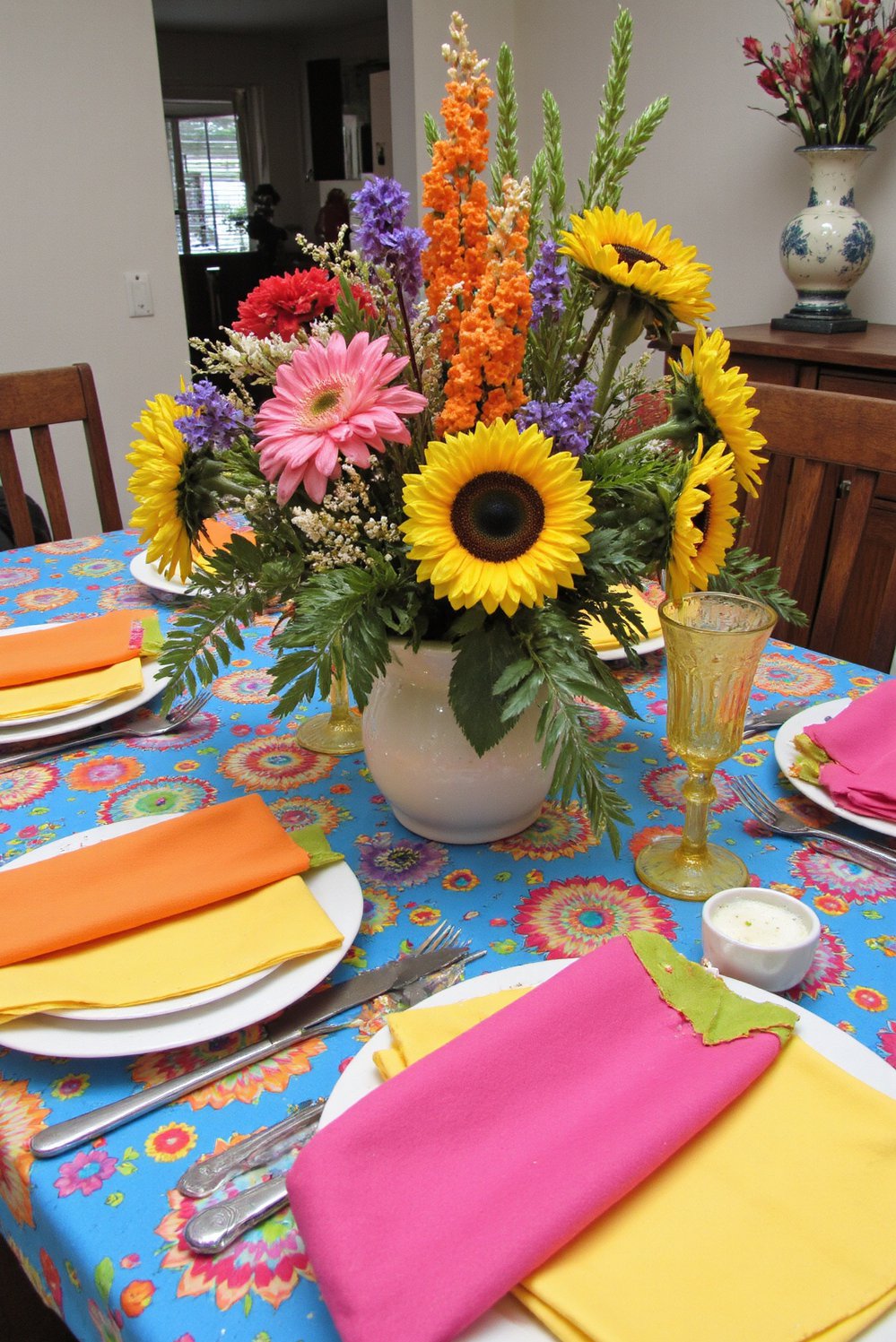 Spring Tablescapes ideas - Bold Spring Tablescape: Vibrant Blooms & Sunflowers - Bright Easter tablescape ideas! A vibrant tablecloth and...