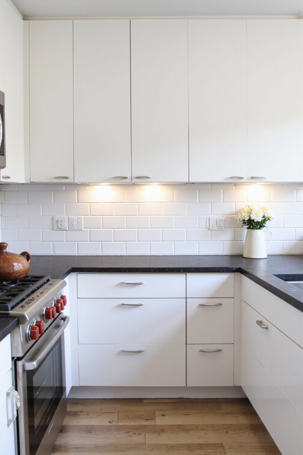 Black and White Modern Kitchen - Sleek White Kitchen with Black Countertops - Sleek, minimalist white modern kitchen. High-gloss white cabinets...