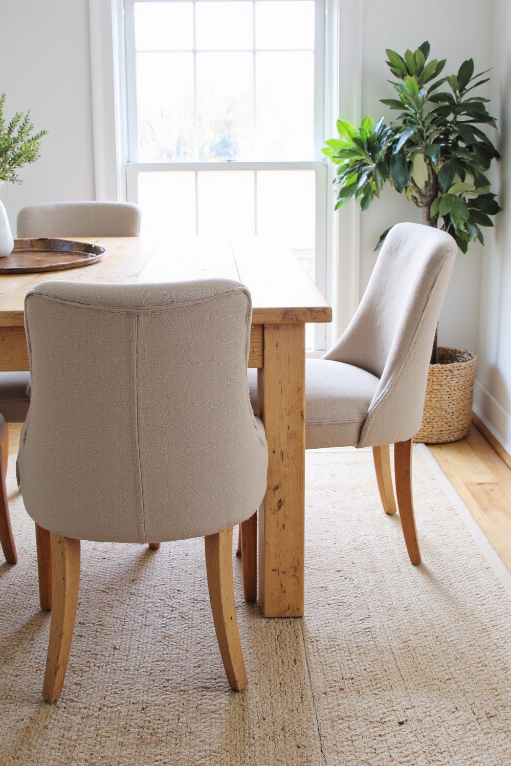 Neutral upholstered dining chairs - Oatmeal Linen Dining Chairs: Light Wood Table Setting - Three oatmeal linen dining chairs shown with a...