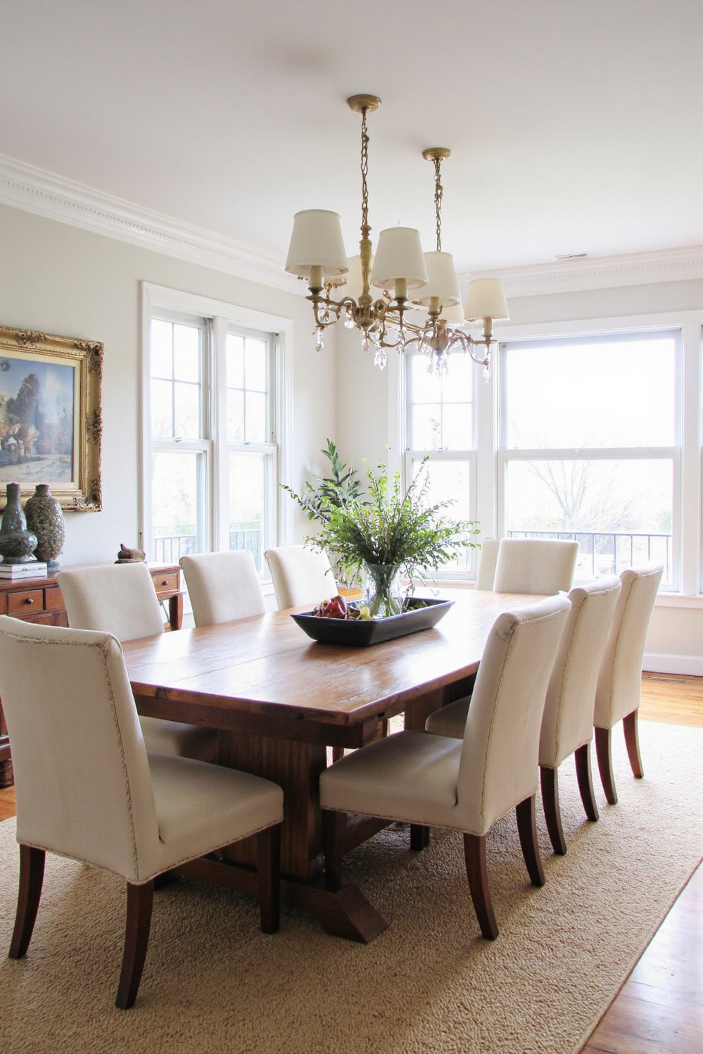 Neutral upholstered dining chairs - Neutral Upholstered Dining Chairs: Farmhouse Style Dining Room - Eight light beige upholstered dining chairs surround a...