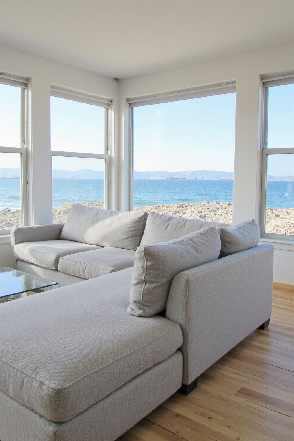 beachy living room ideas - Ocean View Living Room: Light Gray Sectional & Wood Floor - Beach house living room: Ocean views are the...