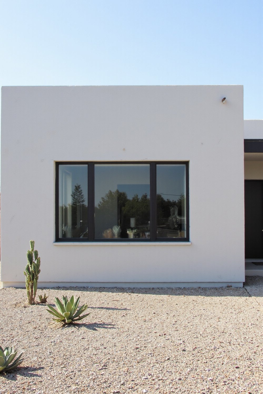 Modern house exteriors - Modern Ranch House Remodel: Light Grey Stucco & Big Windows - This remodeled ranch house boasts a minimalist exterior....