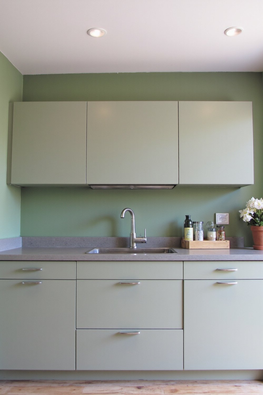 Sage Green Home Decor Ideas - Sleek Sage Green Kitchen: Grey Quartz & Metal Accents - Sage green kitchen cabinets: Sleek, handleless cabinets create...