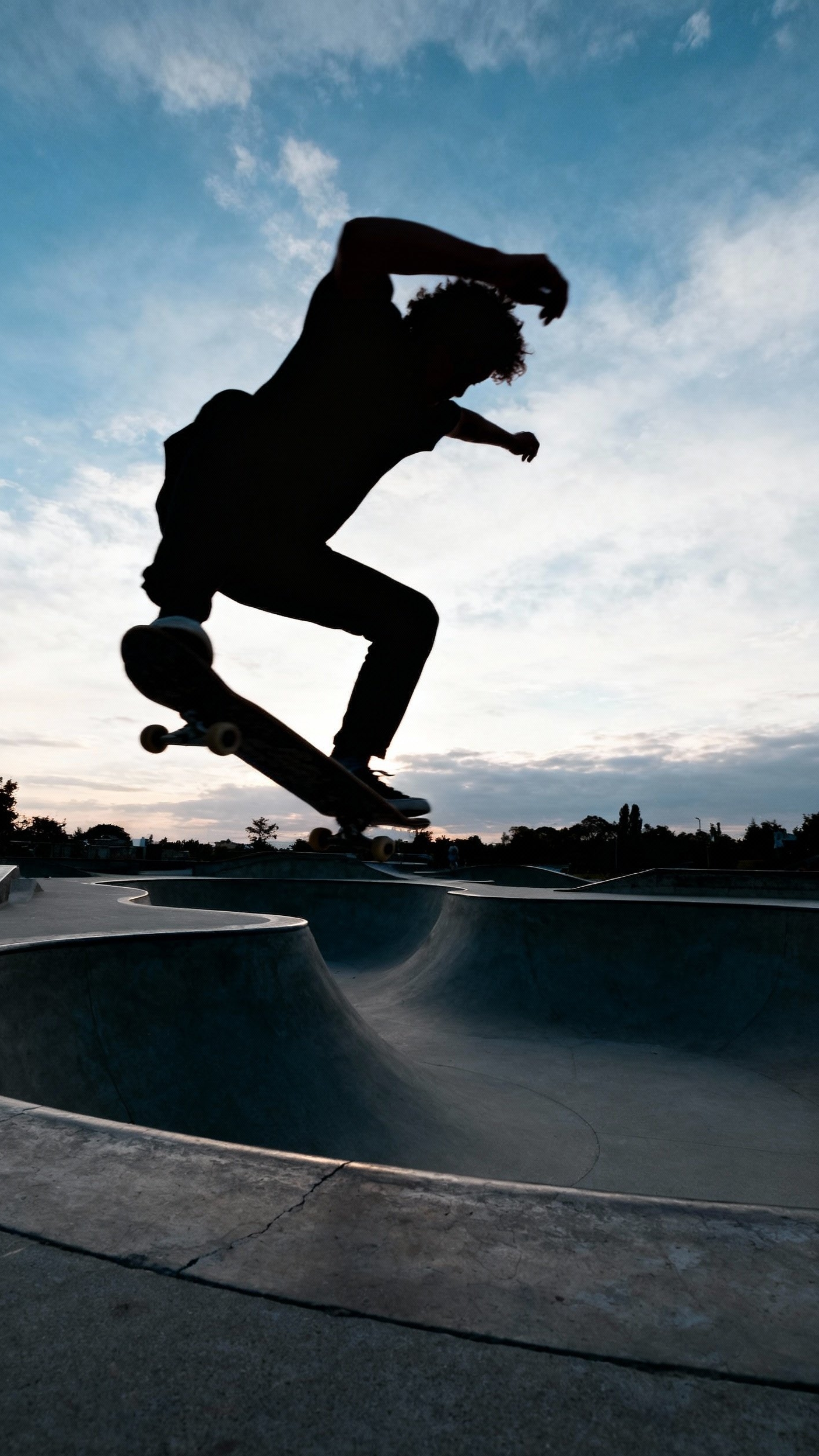 Urban City Photography - Concrete Canvas: City Skateboarding in Motion - The skateboarder soars against a vibrant sky, a...